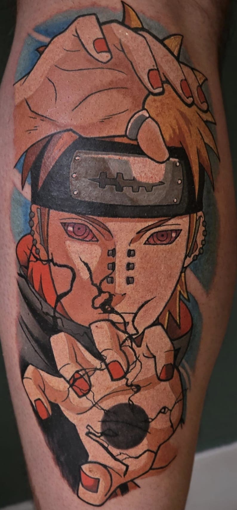 Tatouage de Pain de Naruto avec le Rinnegan, tenant une sphère noire entre ses mains.
