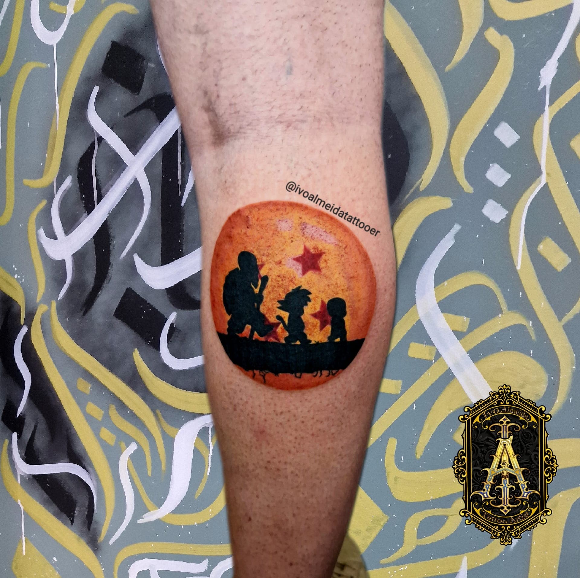 Tatouage d'une Dragon Ball orange montrant les silhouettes de Tortue Géniale, Goku et Krilin.