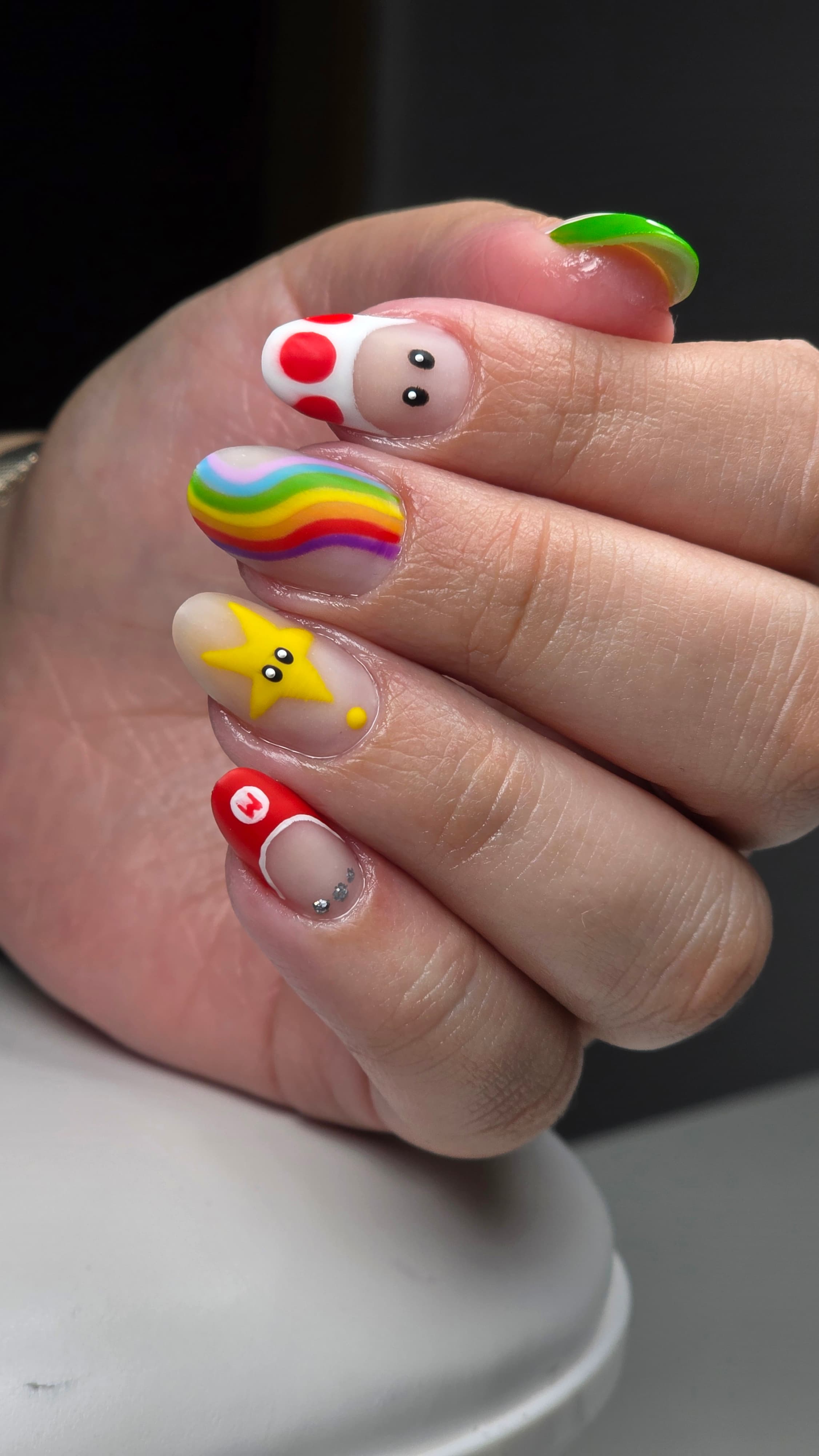 Manucure Super Mario avec Toad, une étoile jaune, un arc-en-ciel et le chapeau rouge.